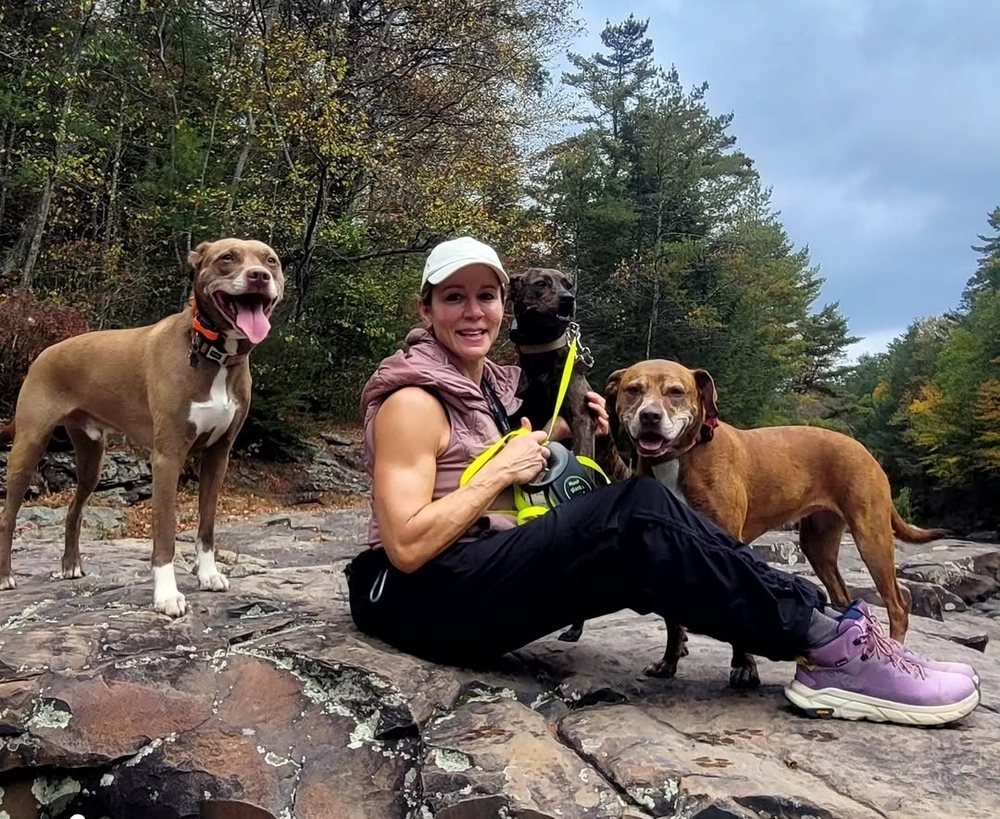 Melissa hiking with her three rescue dogs