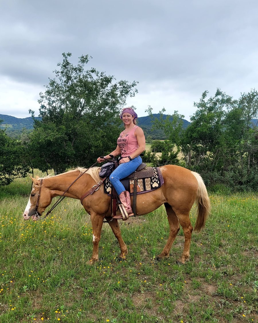 Melissa on horseback in a wildflower field